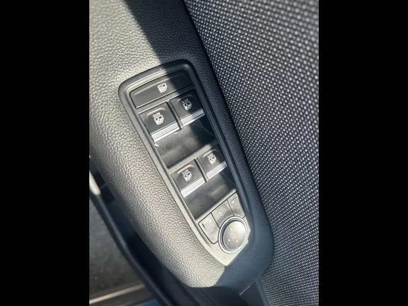 Gros plan sur les commandes de lève-vitres et rétroviseurs côté conducteur du Renault Captur gris Cassiopée métallisé.