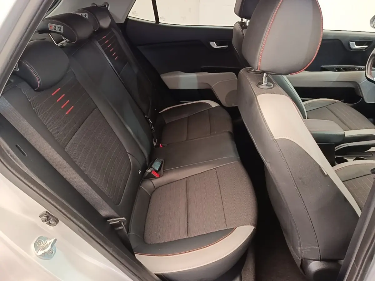 Vue intérieure côté droit montrant la banquette arrière noire avec surpiqûres rouges du KIA Stonic gris clair 2019.