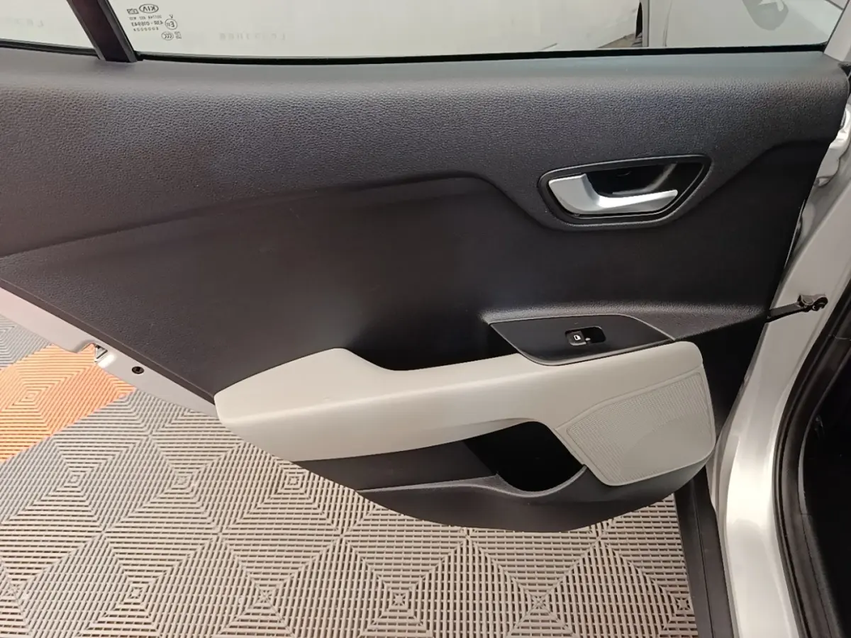 Vue intérieure côté gauche de la porte avant gris clair du KIA STONIC 2019 avec poignée argentée et accoudoir clair.