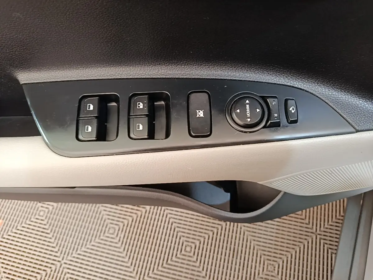 Panneau de commandes des vitres et rétroviseurs côté conducteur, intérieur gris clair du Kia Stonic 2019.