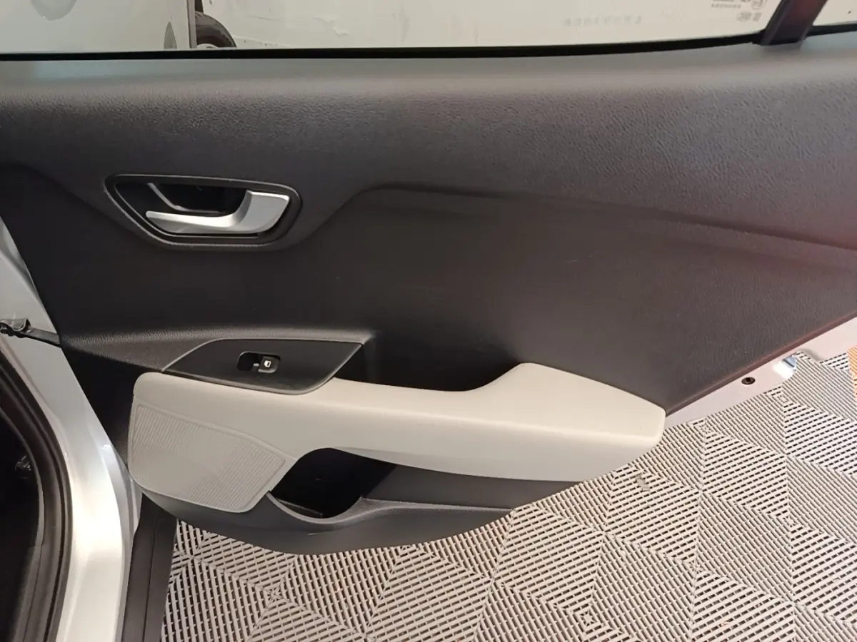 Vue intérieure côté gauche de la porte avant gris clair du KIA STONIC 2019 avec accoudoir beige et poignée argentée.