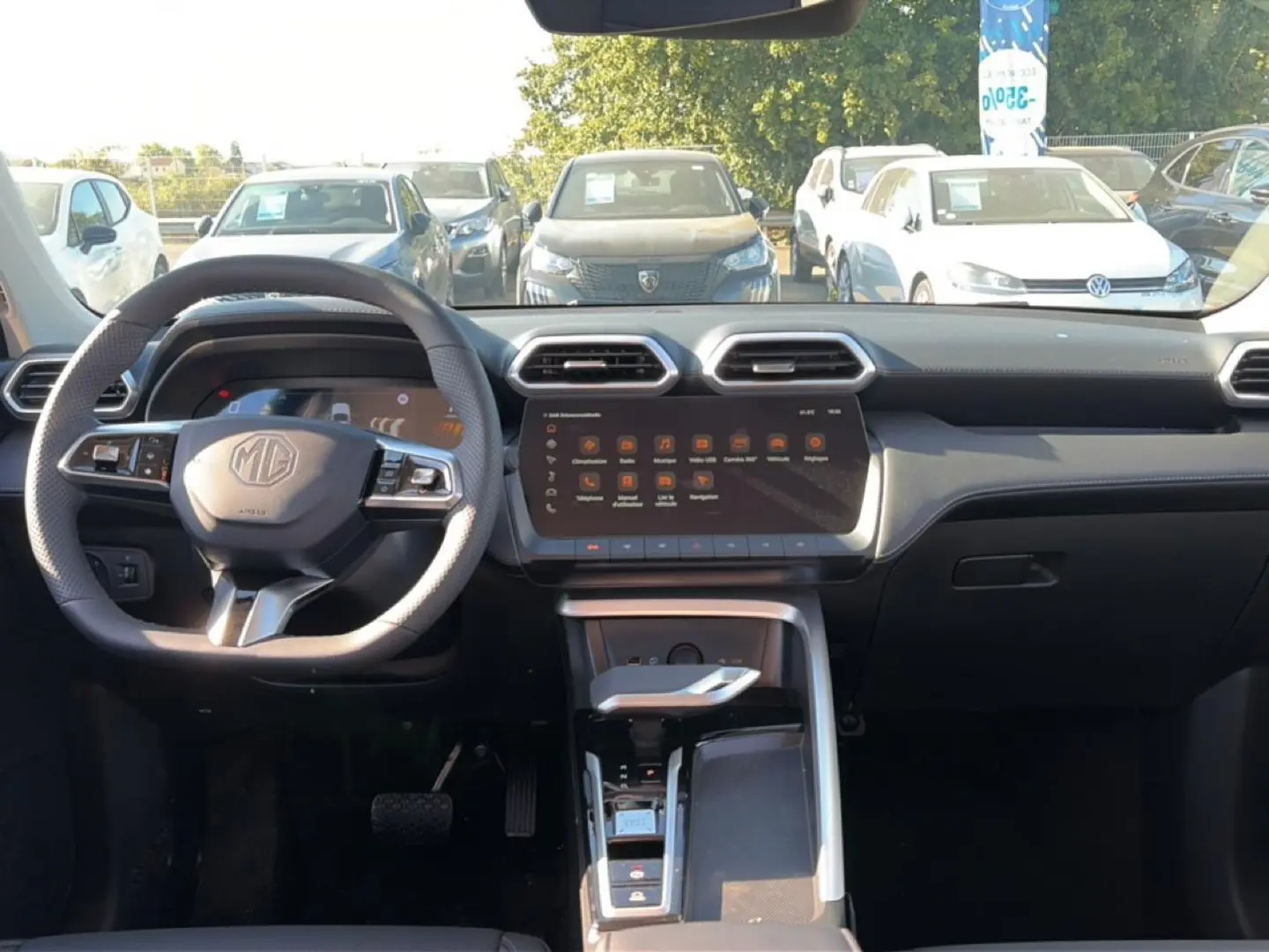 Vue intérieure avant du MG Motor ZS 1.5 hybrid 197 luxury 2026, tableau de bord et volant multifonction gris.