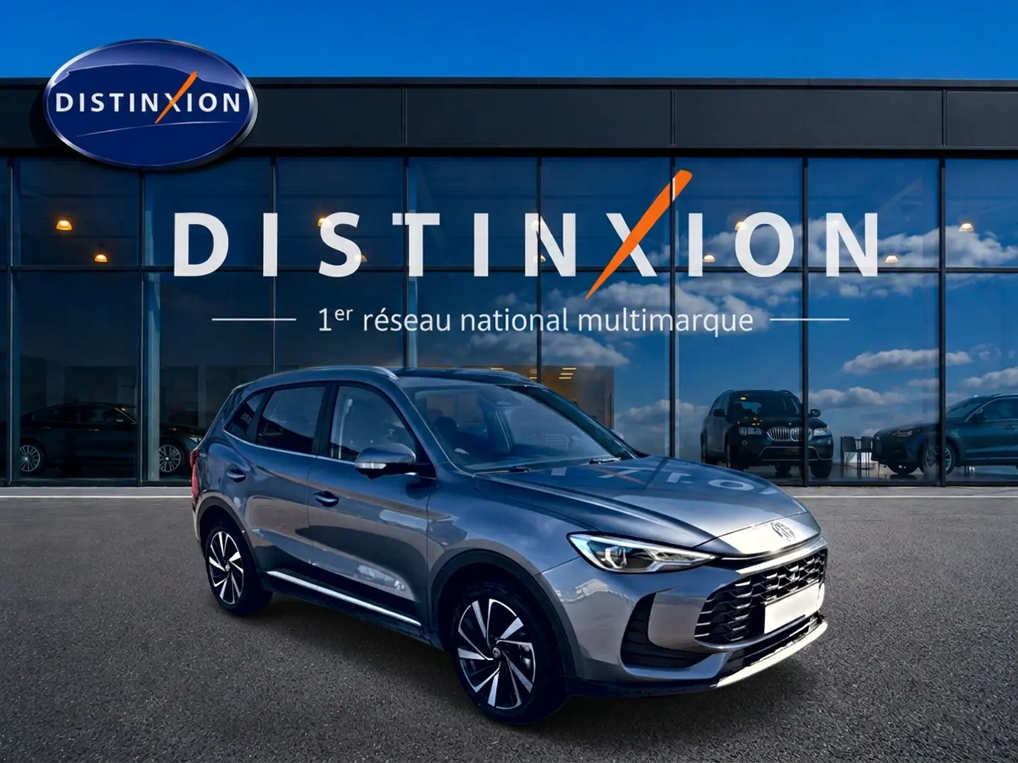 MG Motor ZS 1.5 hybrid 197 luxury gris, vue 3/4 avant droit, jantes alliage et calandre marquée.