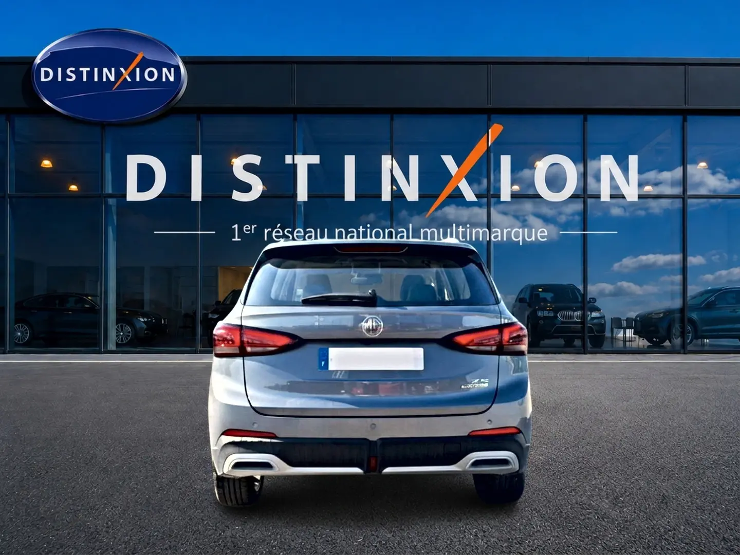 Vue arrière d'un MG Motor ZS gris 1.5 hybrid 197 luxury, avec feux LED et double sortie d'échappement intégrée.