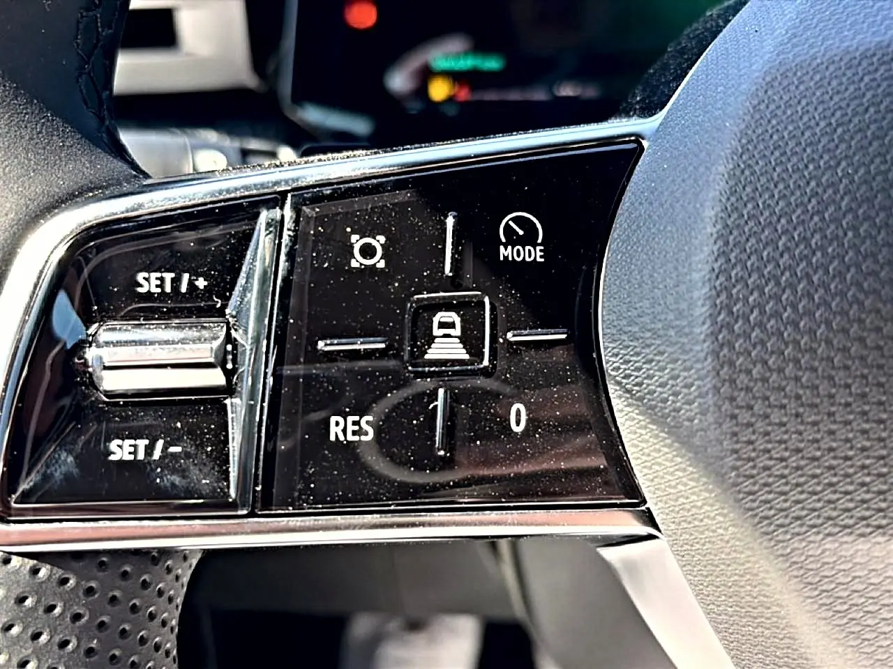 Gros plan sur les commandes de régulateur de vitesse sur le volant noir de la Renault Clio VI 1.2 TCe 115 Techno EDC.