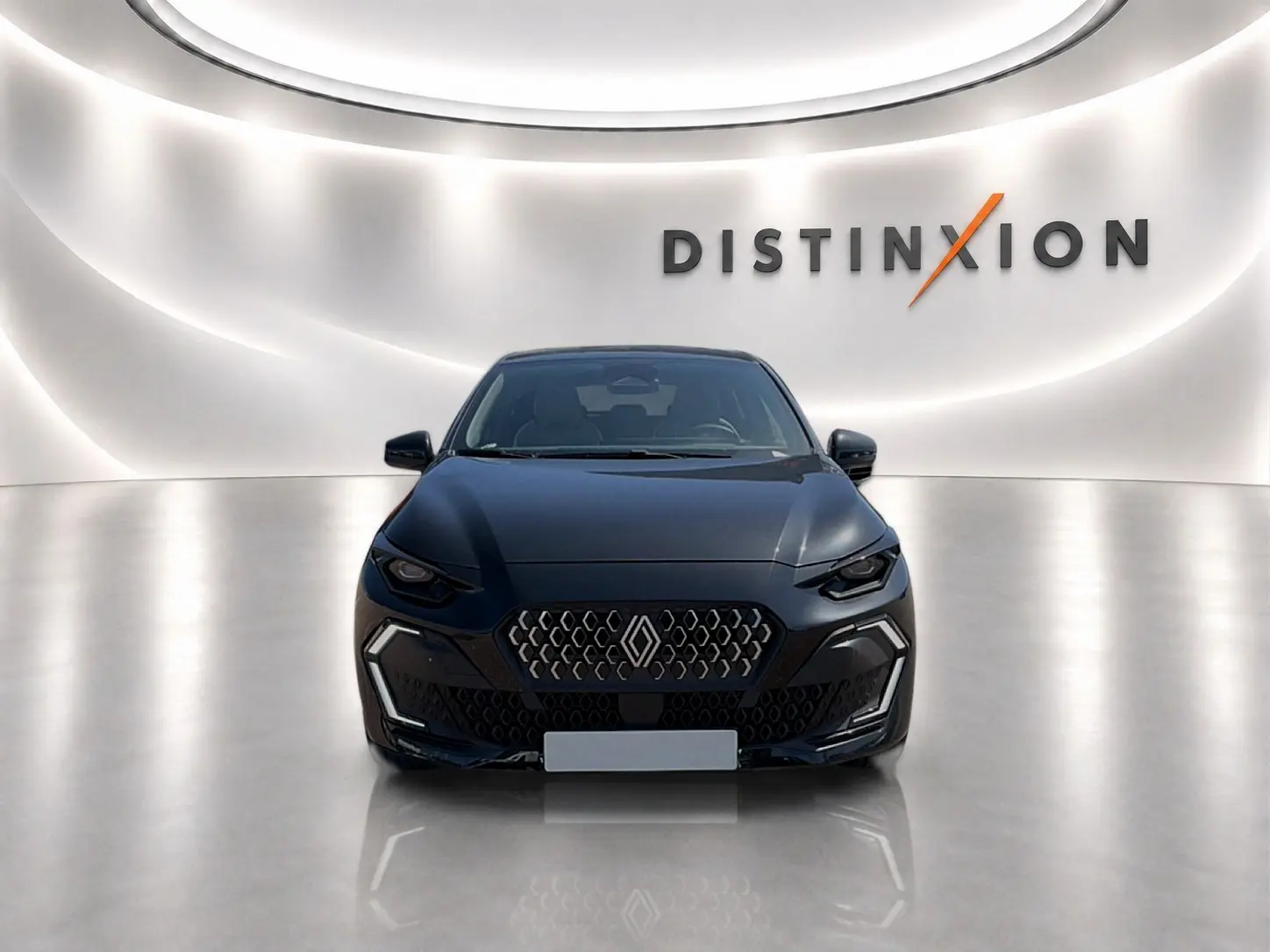 Vue avant d'une Renault Clio VI noire, avec calandre distinctive et éclairage LED, sur fond blanc lumineux "Distinxion".
