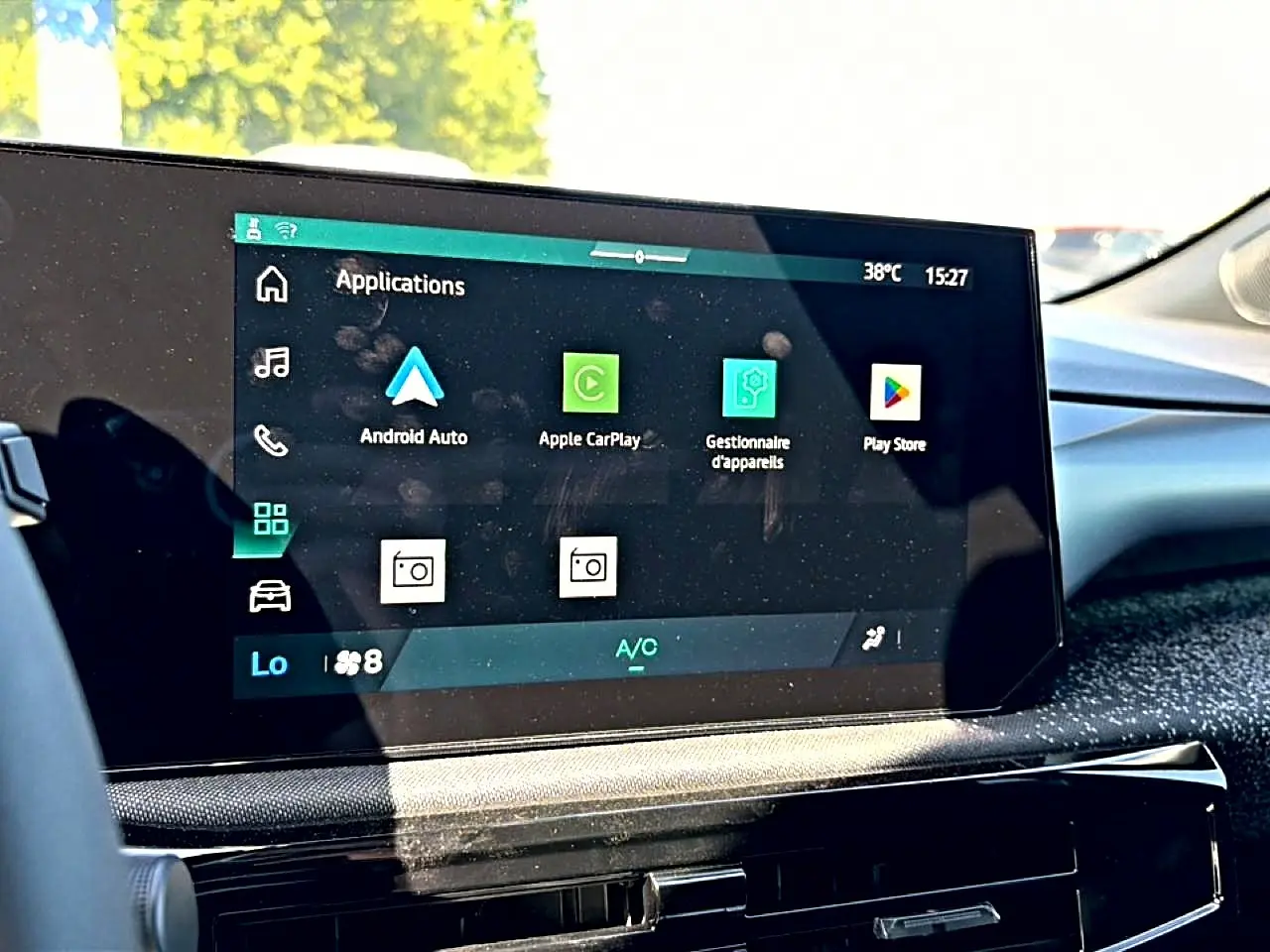 Écran tactile central de la Renault Clio VI noir, affichant les applications Android Auto et Apple CarPlay, intérieur lumineux.
