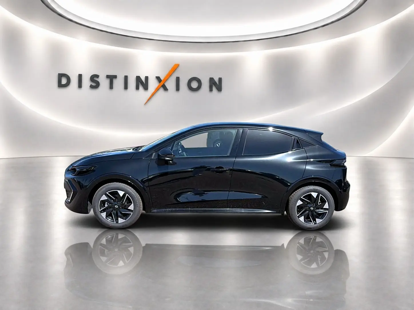 Profil côté gauche de la Renault Clio VI noire 2026 avec jantes alu et vitres arrière surteintées dans un showroom lumineux.