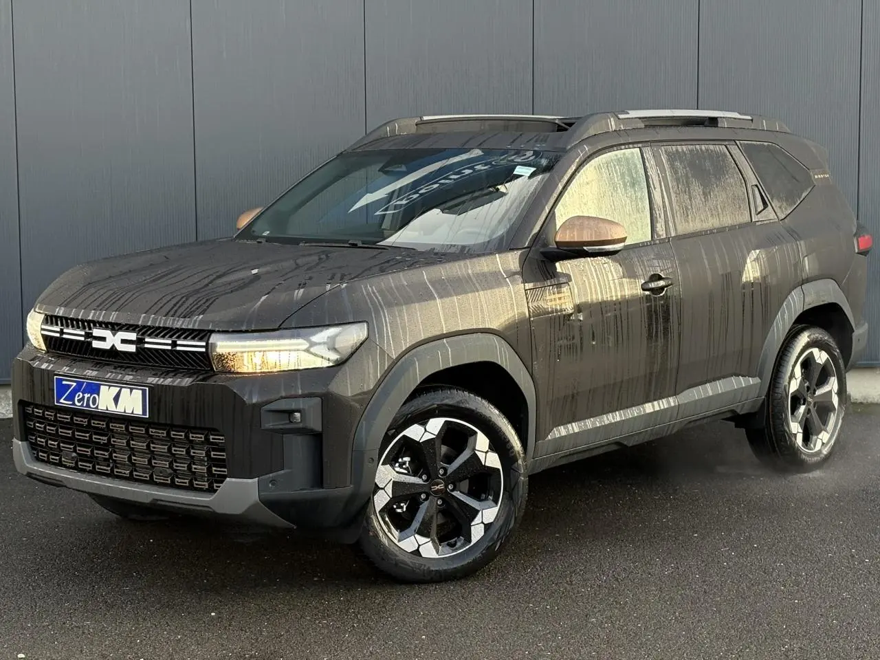 Vue 3/4 avant droit du Dacia Bigster 2025 noir nacré avec jantes alliage et toit panoramique visible