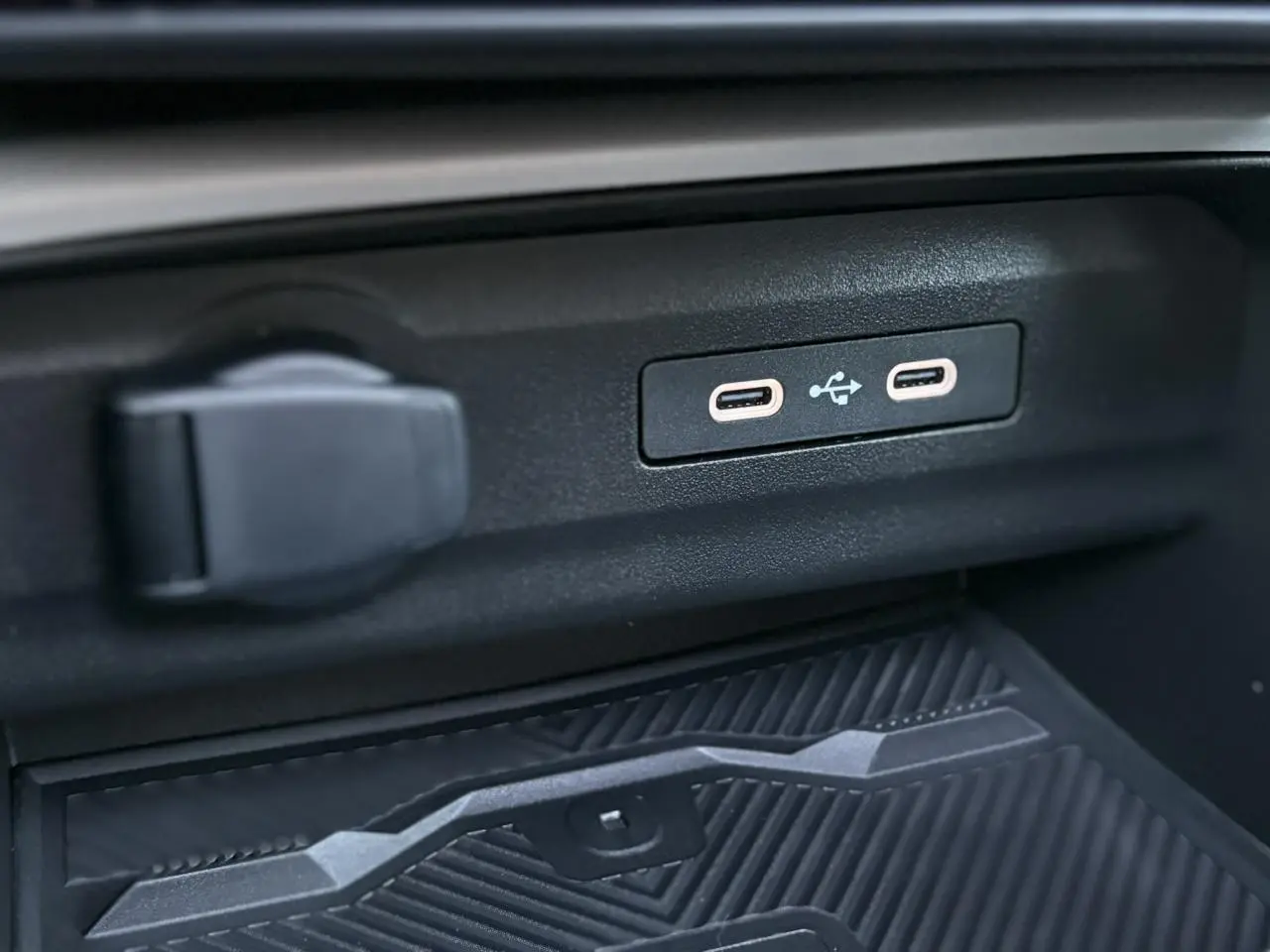Gros plan sur les ports USB-C et prise 12V dans l'habitacle du Dacia Bigster noir nacré 2025.