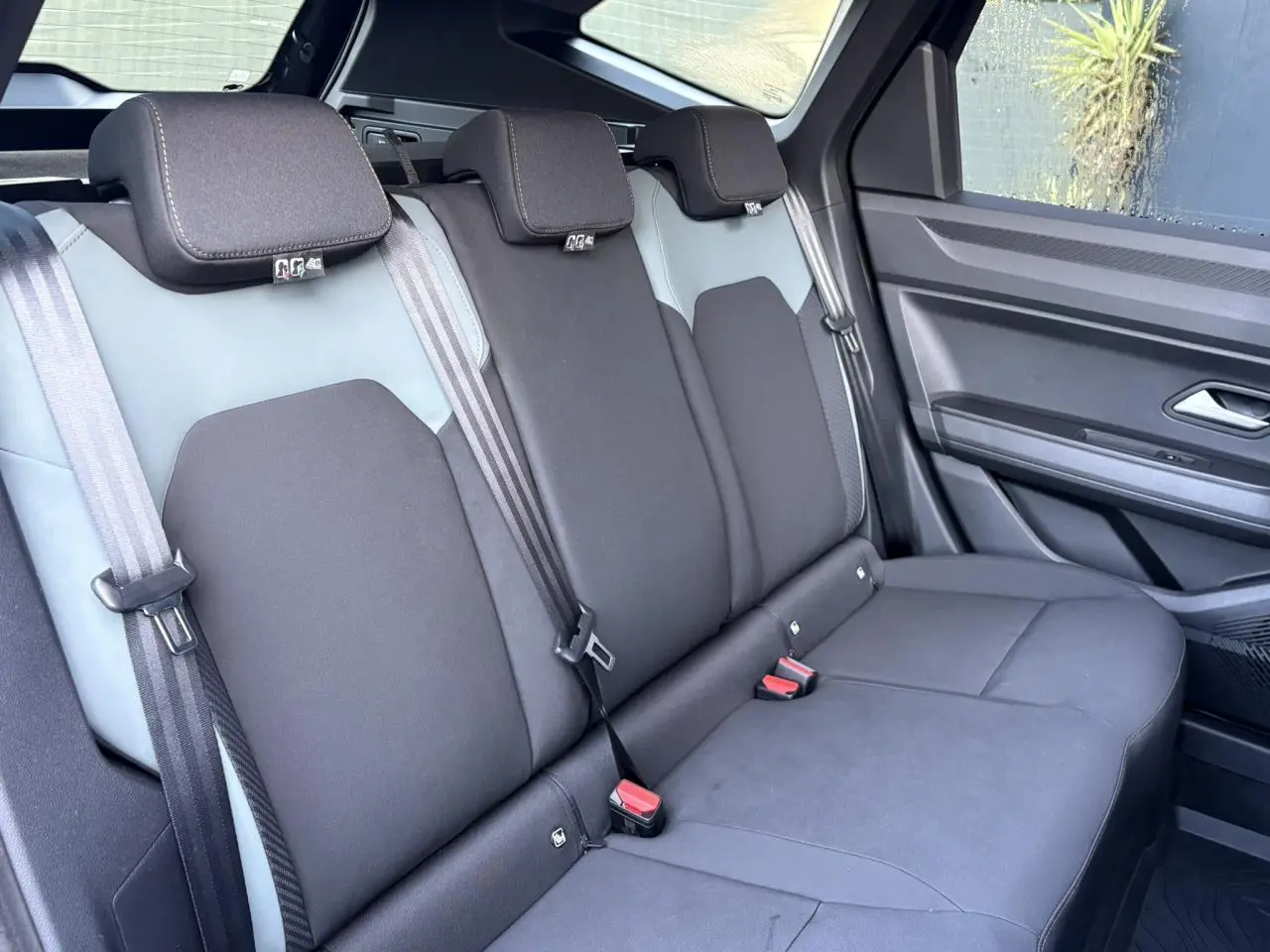 Vue latérale droite de la banquette arrière noire et grise du Dacia Bigster 2025 avec ceintures et appuie-têtes intégrés.