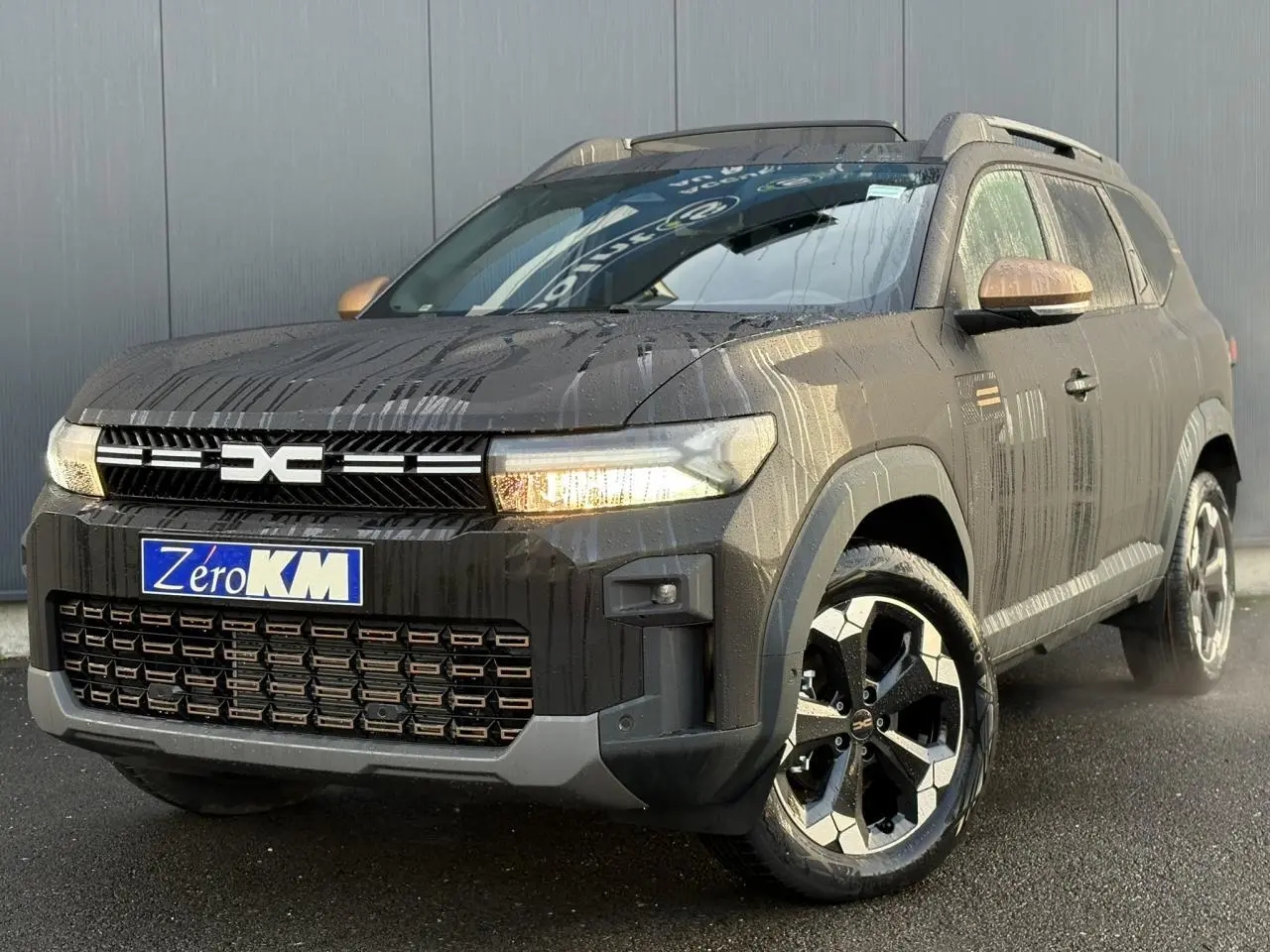 Vue 3/4 avant du Dacia Bigster noir nacré 2025 avec jantes alliage noires et rétroviseurs bronze.