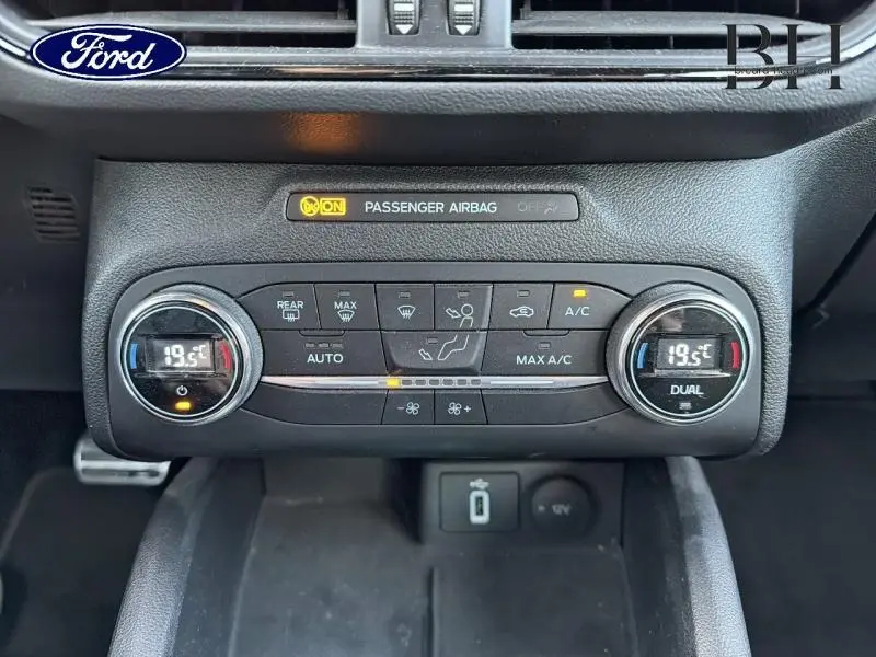 Vue rapprochée du panneau de climatisation bi-zone avec affichage digital à 19,5°C dans une Ford Focus gris lunaire.