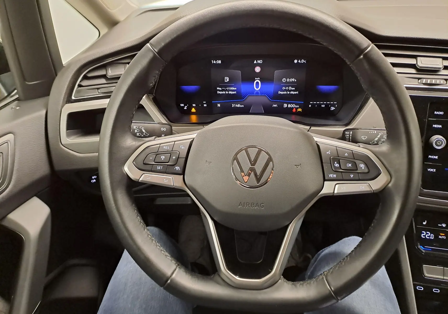 Vue intérieure centrée sur le volant multifonction noir du Volkswagen Touran 2025 avec tableau de bord numérique allumé.