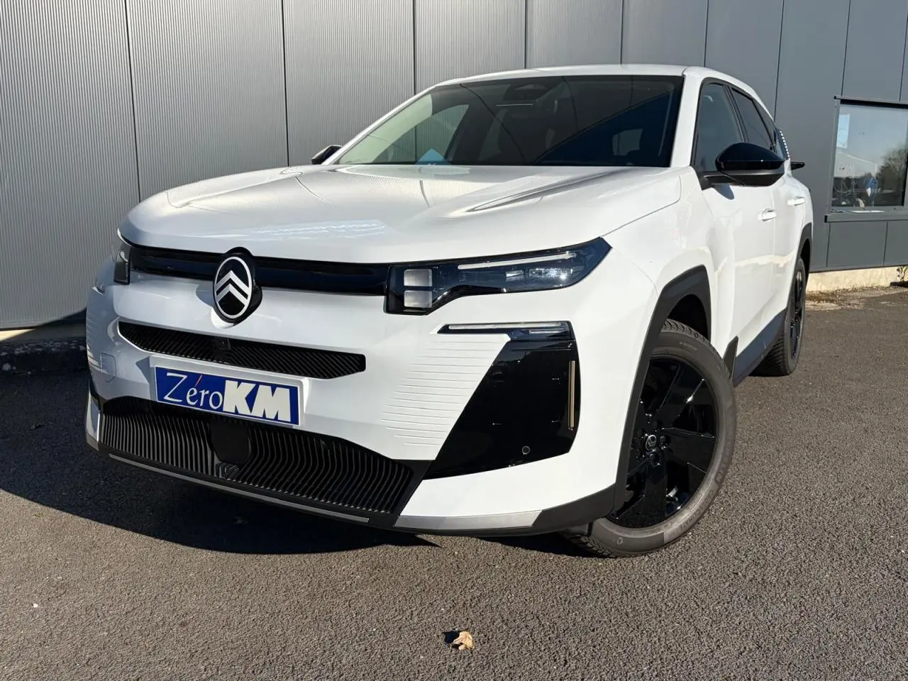 Vue 3/4 avant droite du Citroën C5 Aircross blanc Okenite avec jantes noires et calandre noire distinctive.