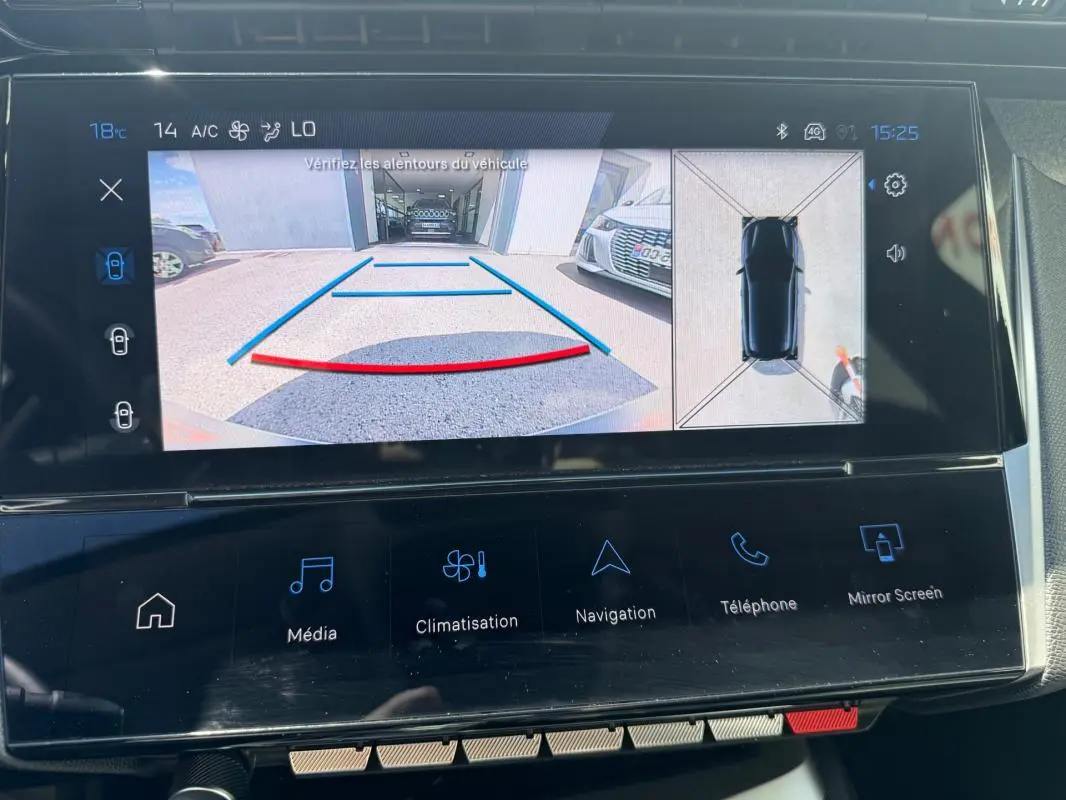 Écran tactile du cockpit numérique montrant la caméra de recul et la vue à 360° du Peugeot 308 Hybrid noir, intérieur moderne.