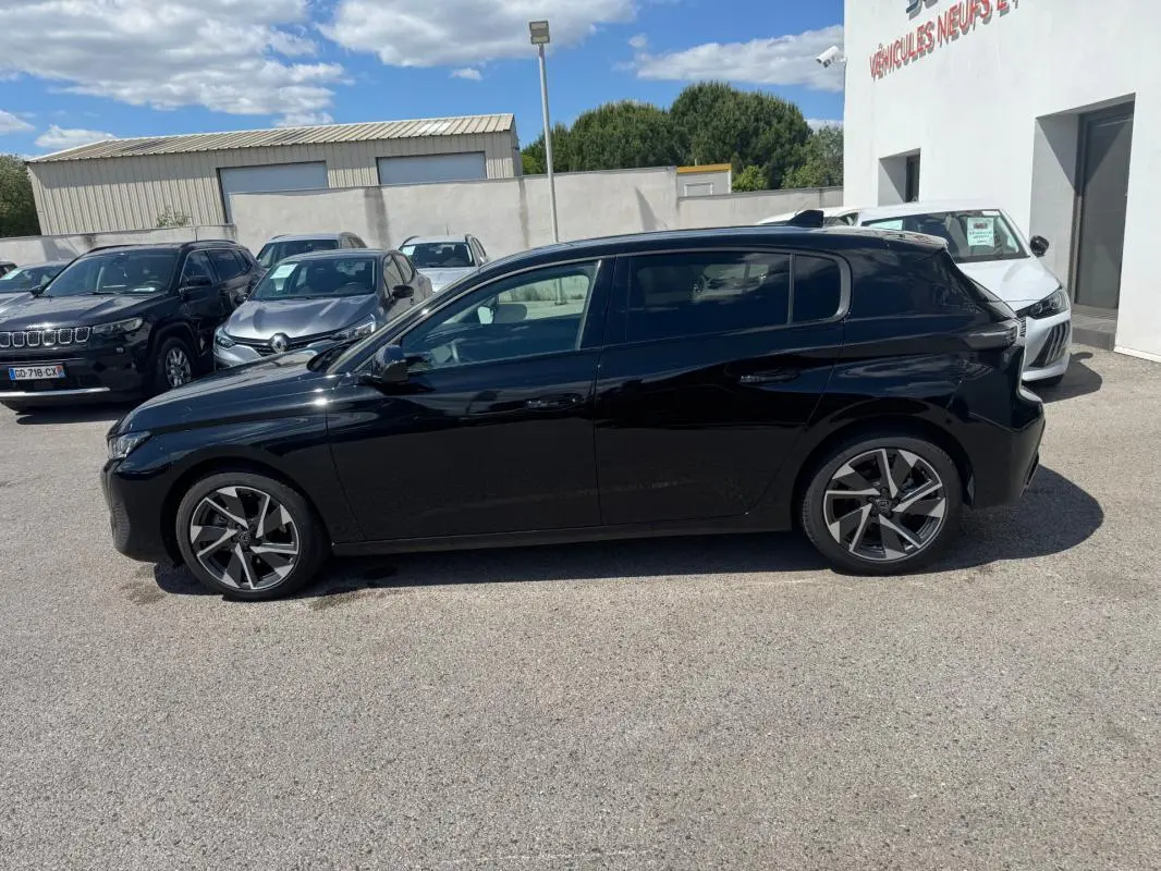 Peugeot 308 Hybrid noir vue de profil côté gauche, avec jantes alliage 17 pouces et vitres teintées.