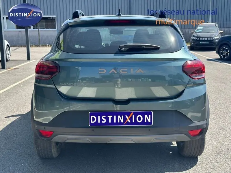 Vue arrière d'une Dacia Sandero Stepway 2025 en vert cèdre métallisé avec logo et feux arrière LED visibles.