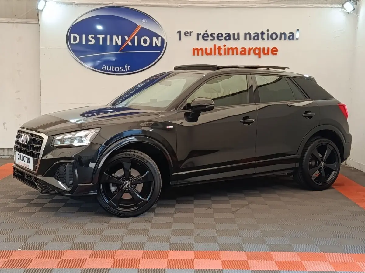 Audi Q2 35 TFSI S Line noir vue de profil côté gauche dans un showroom avec jantes noires distinctives.