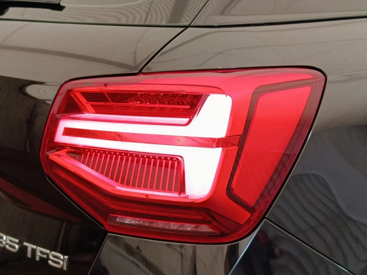 Gros plan sur le feu arrière droit rouge et blanc d’un Audi Q2 noir 35 TFSI 150 S Tronic S Line de 2021.