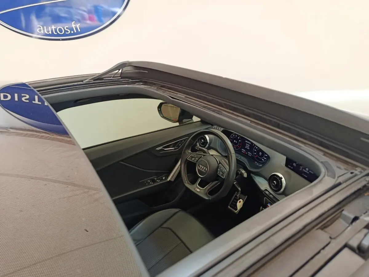 Vue intérieure côté conducteur de l'Audi Q2 noir 2021, volant cuir multifonctions et tableau de bord digital.