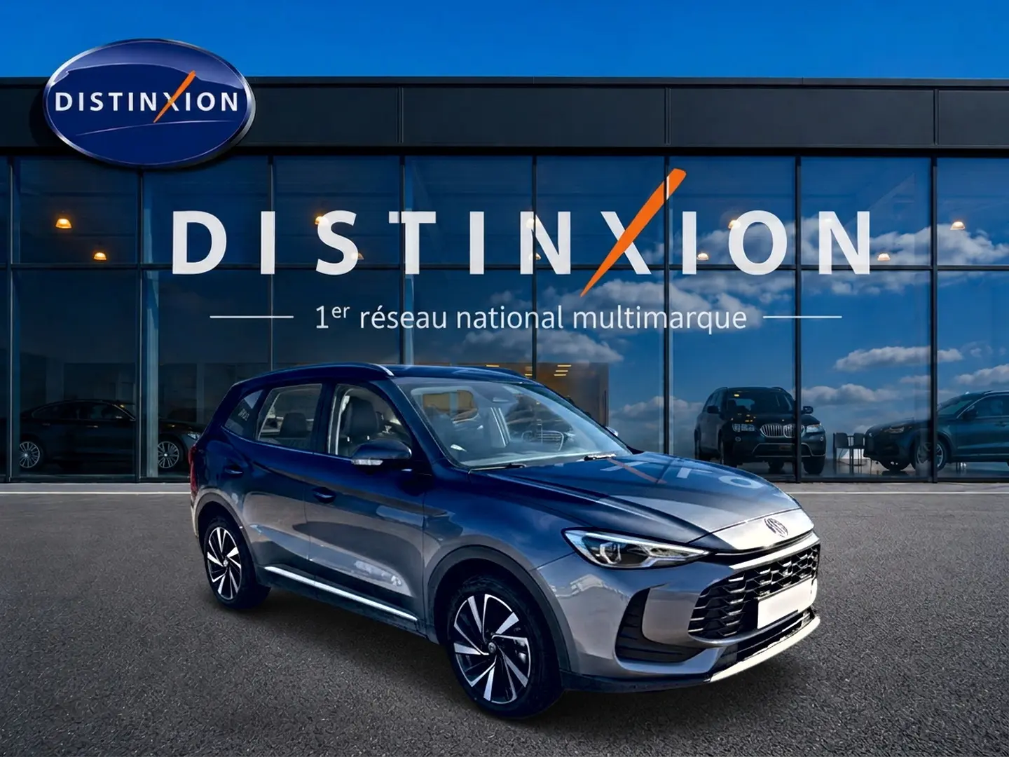 MG Motor ZS 1.5 hybrid gris en 3/4 avant droit, avec jantes alliage et calandre noire distinctive.