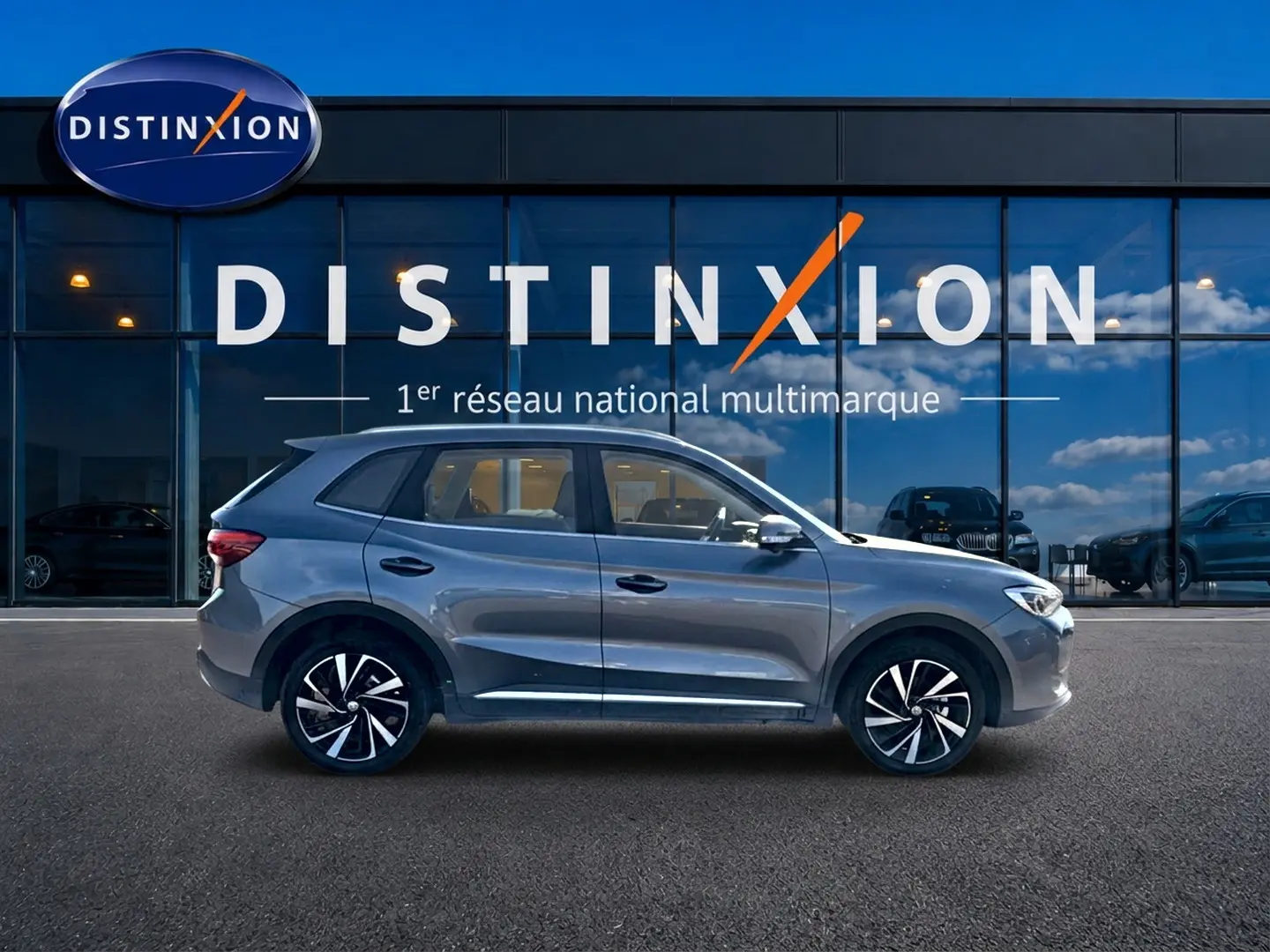 Vue profil côté gauche du MG Motor ZS 1.5 hybrid gris 2026, avec jantes alliage noires et détails chromés.
