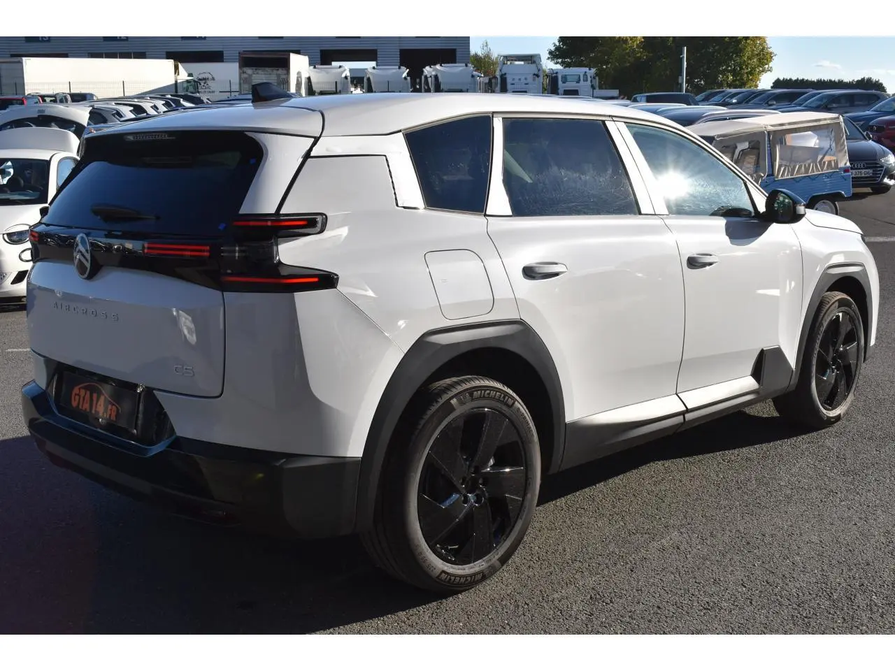 Vue 3/4 arrière droite d'un Citroën C5 Aircross blanc avec jantes noires et feux arrière LED distinctifs.