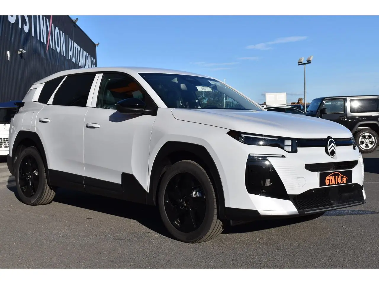 Vue 3/4 avant droit du Citroën C5 Aircross blanc avec jantes noires et détails noirs contrastants.