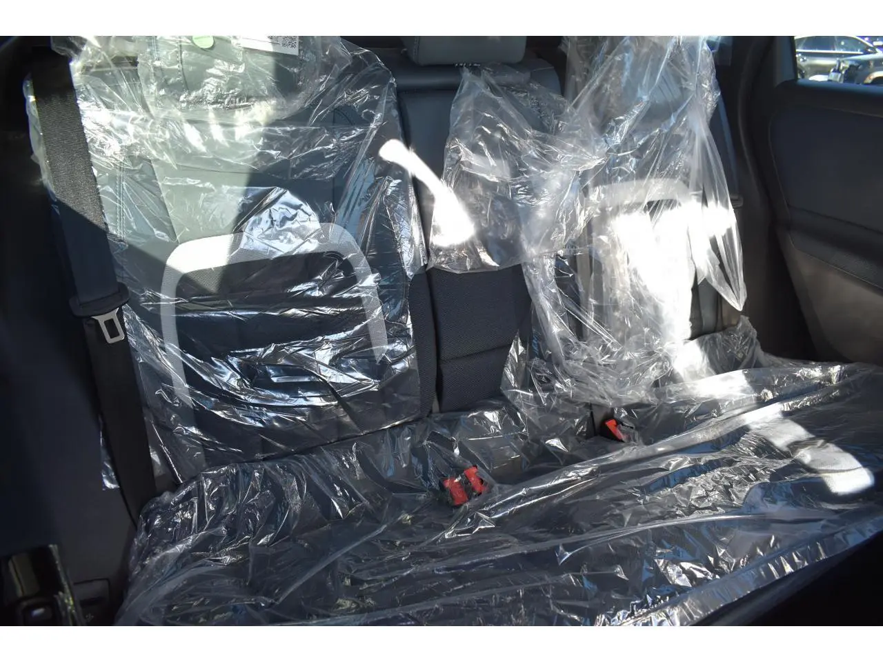Vue intérieure arrière du Citroën C5 Aircross blanc 2026, sièges protégés par housses plastiques transparentes.