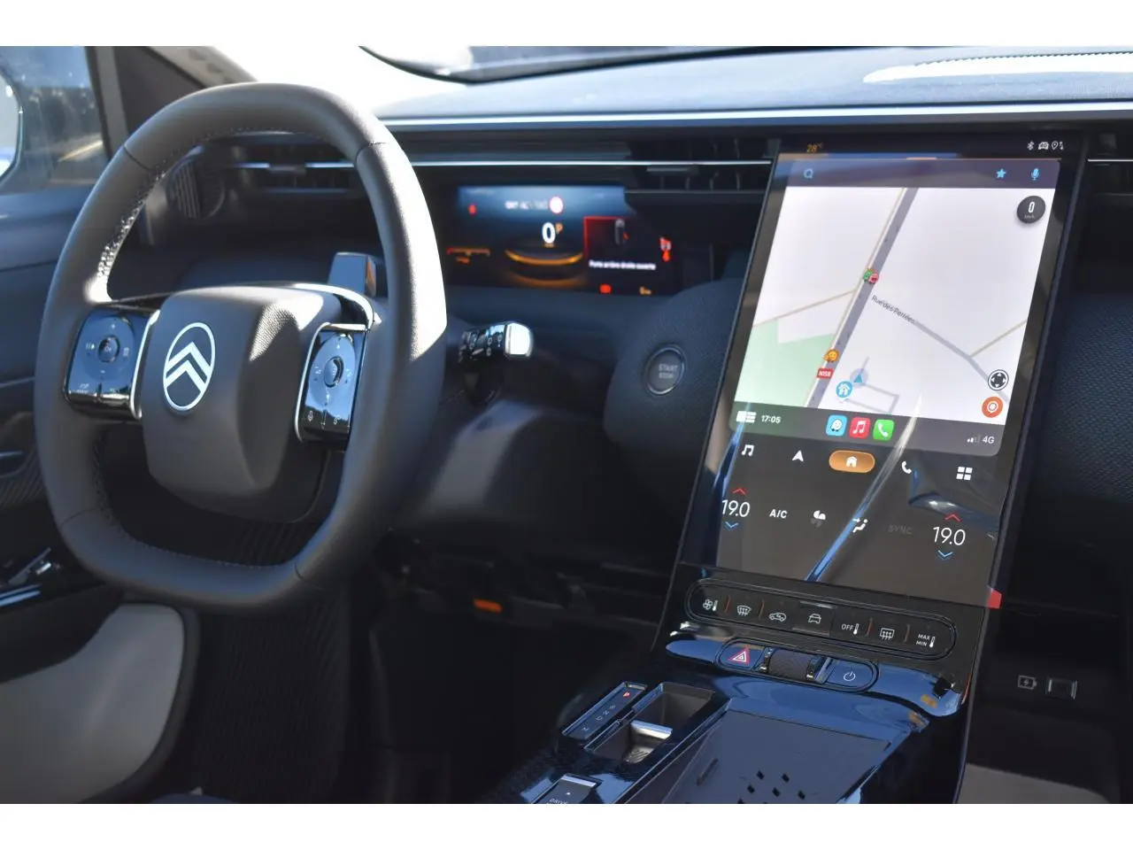 Vue intérieure du tableau de bord du Citroën C5 Aircross hybride blanc, avec écran tactile vertical et volant multifonctions.