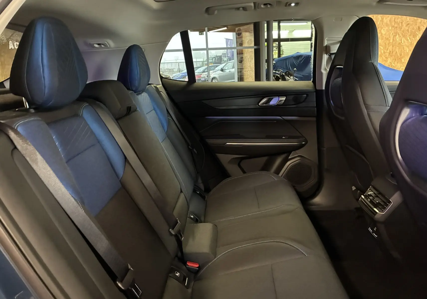 Vue intérieure côté droit des sièges arrière en tissu noir et bleu du Lynk & Co 01 hybride rechargeable 2023.