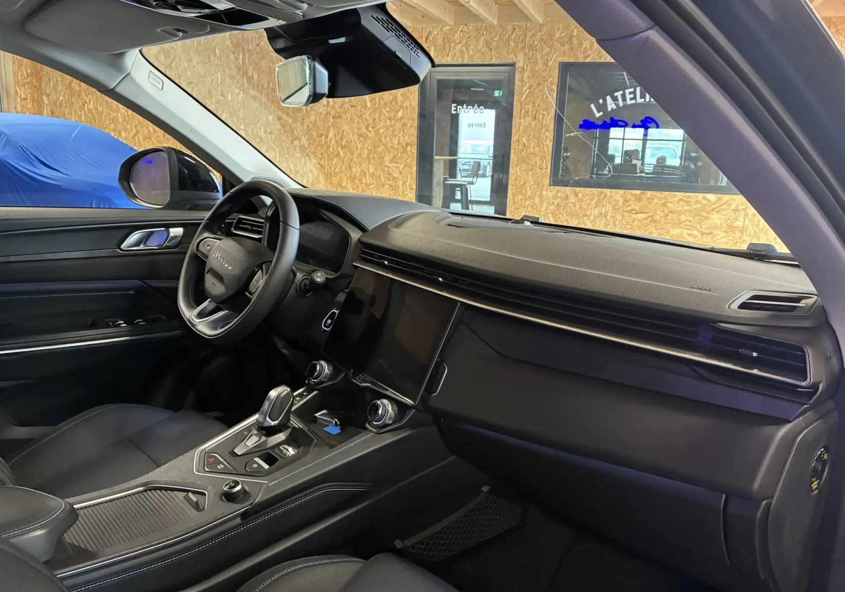 Intérieur noir bleu du Lynk & Co 01 2023, vue côté conducteur montrant tableau de bord et console centrale moderne.