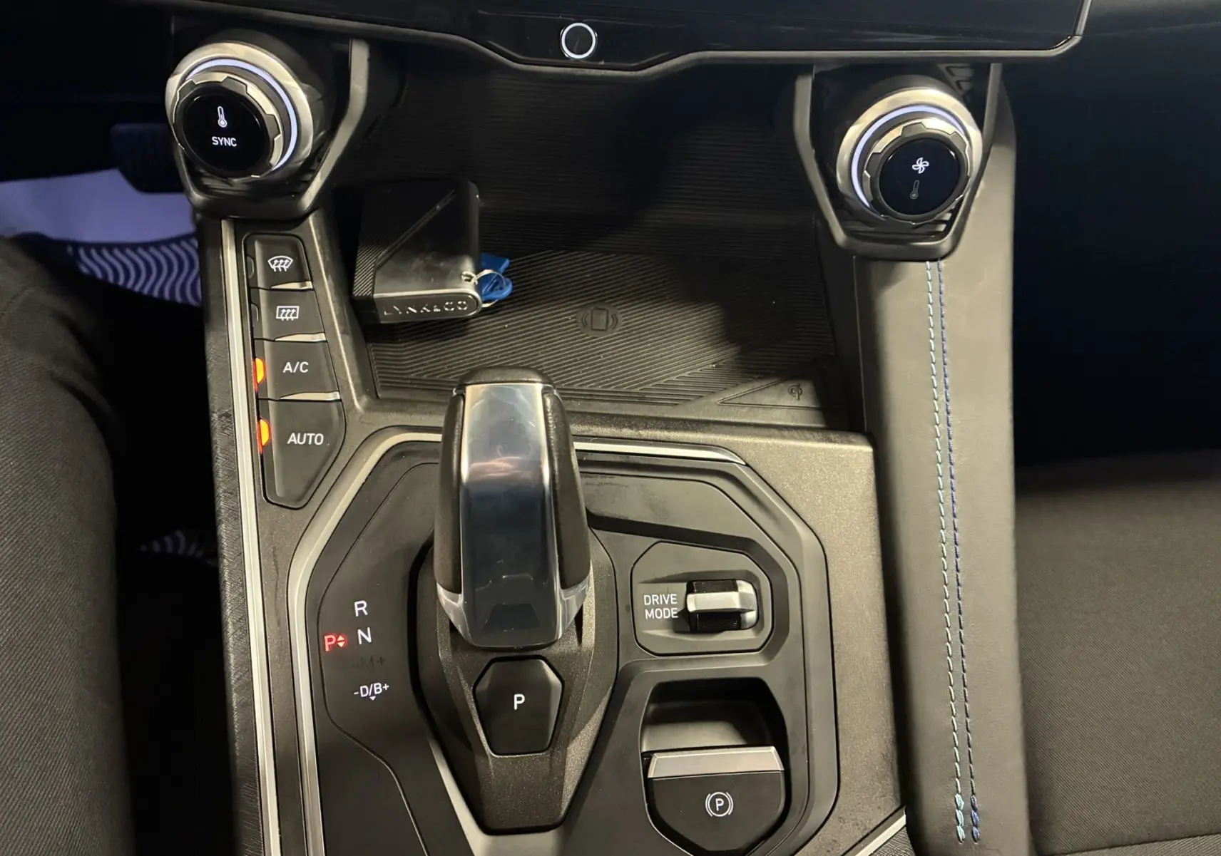 Vue rapprochée de la console centrale du Lynk & Co 01 bleu, avec levier de vitesses automatique et commandes climatisation.