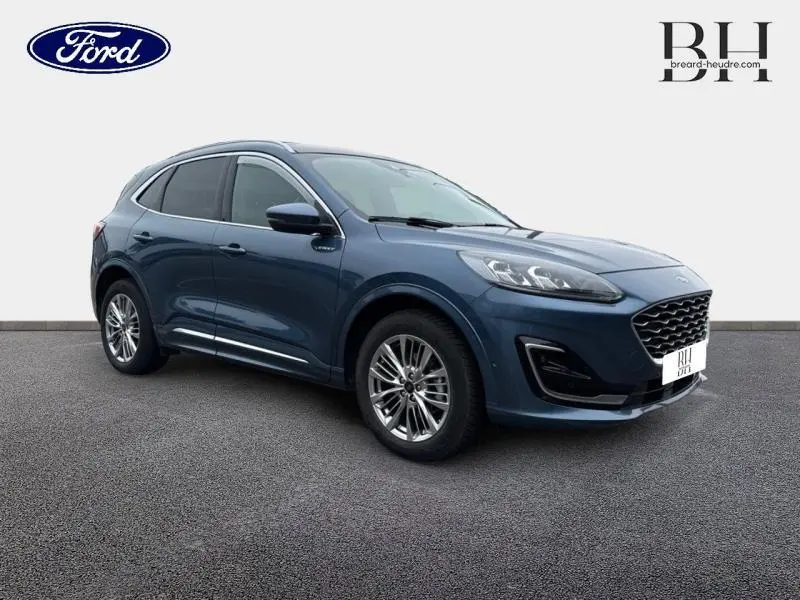 Ford Kuga bleu azur métallisé en vue 3/4 avant droit, avec toit panoramique et jantes alu élégantes.