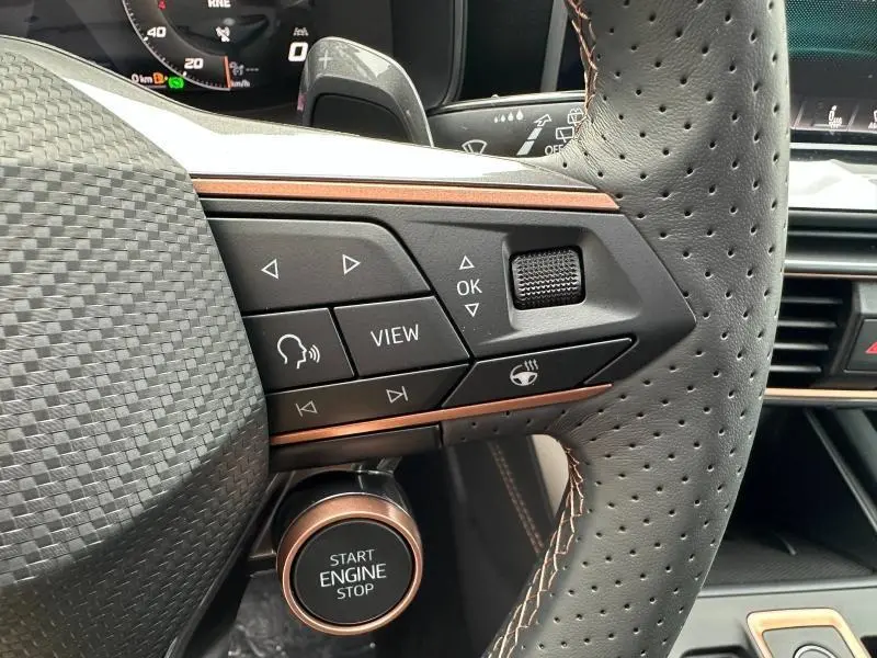 Gros plan sur le volant perforé et les commandes multifonctions côté gauche du CUPRA Formentor gris Graphène avec bouton start/stop visible.