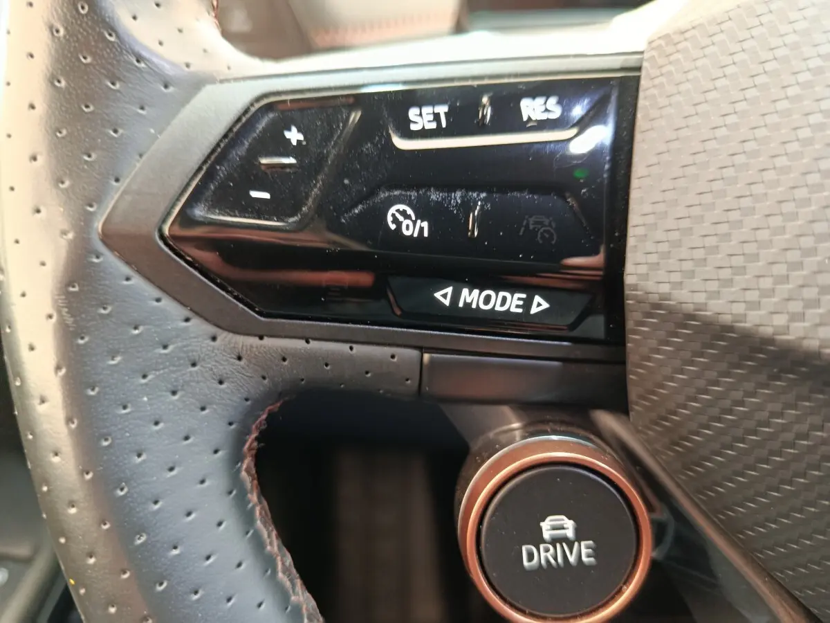Gros plan sur le volant cuir perforé et les commandes multifonctions noires du CUPRA Born gris foncé 2023.