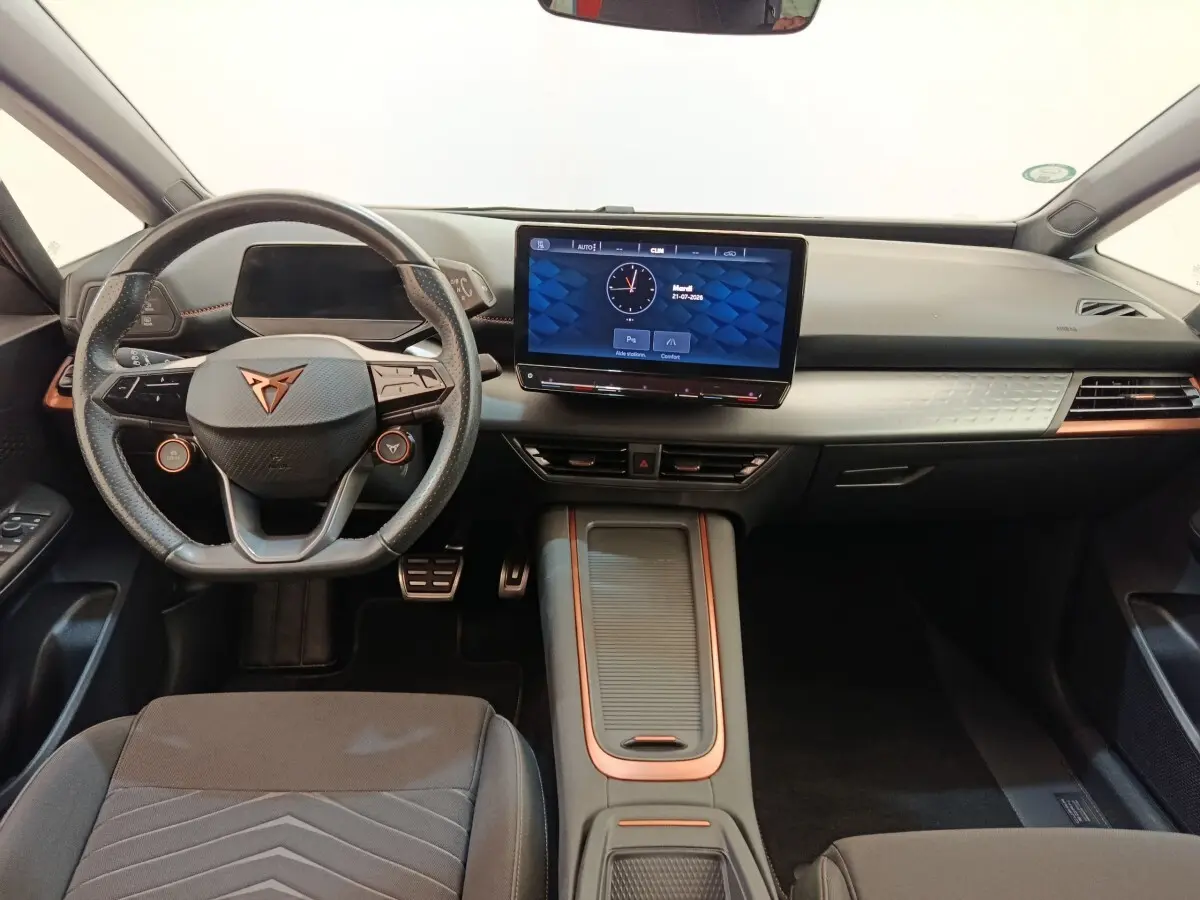 Vue intérieure avant du tableau de bord et volant cuir noir avec touches cuivre du CUPRA BORN 230ch gris foncé 2023 électrique.