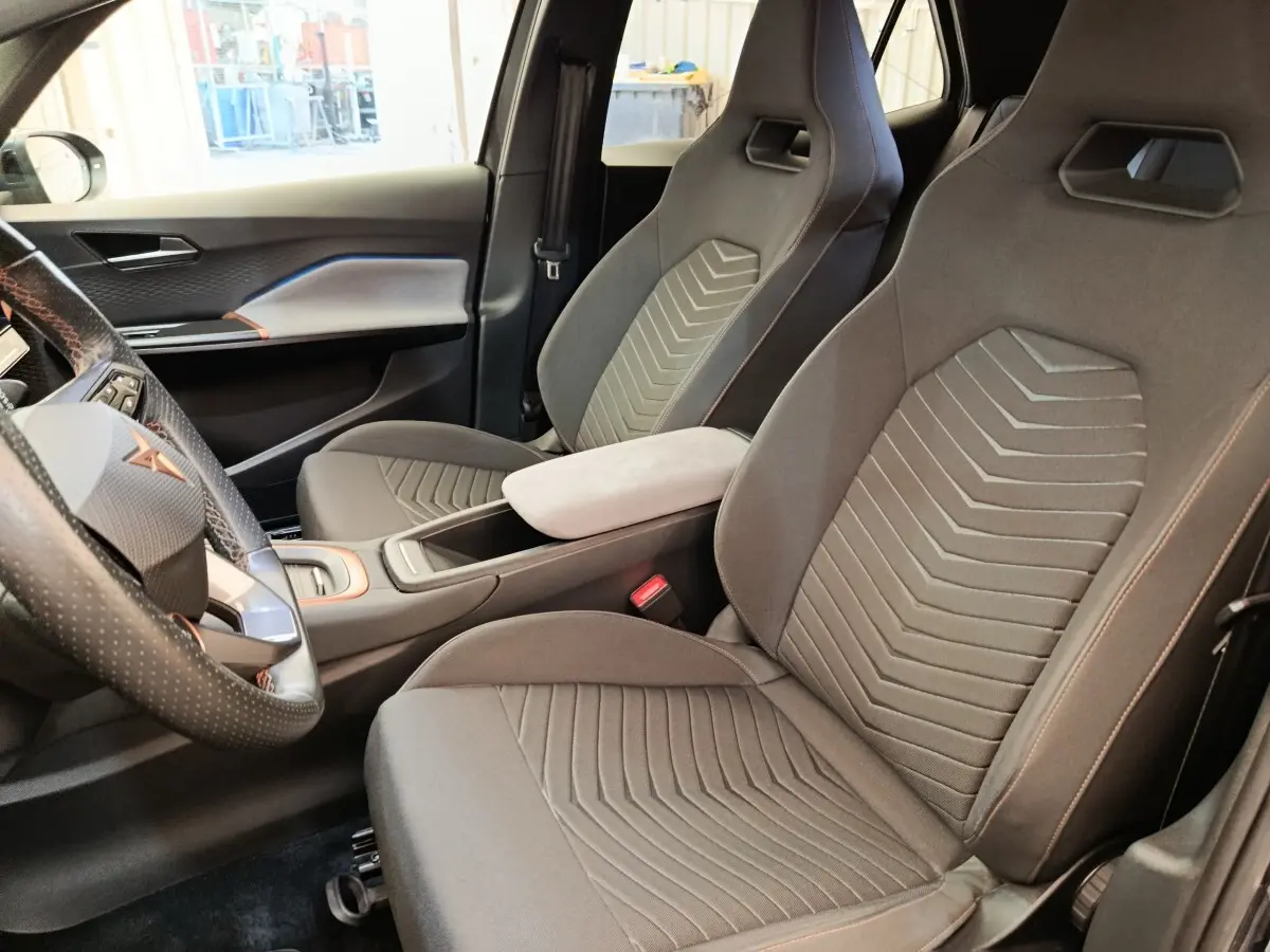 Vue intérieure côté conducteur de la CUPRA BORN 230ch gris foncé, avec sièges sport et volant cuir multifonctions.