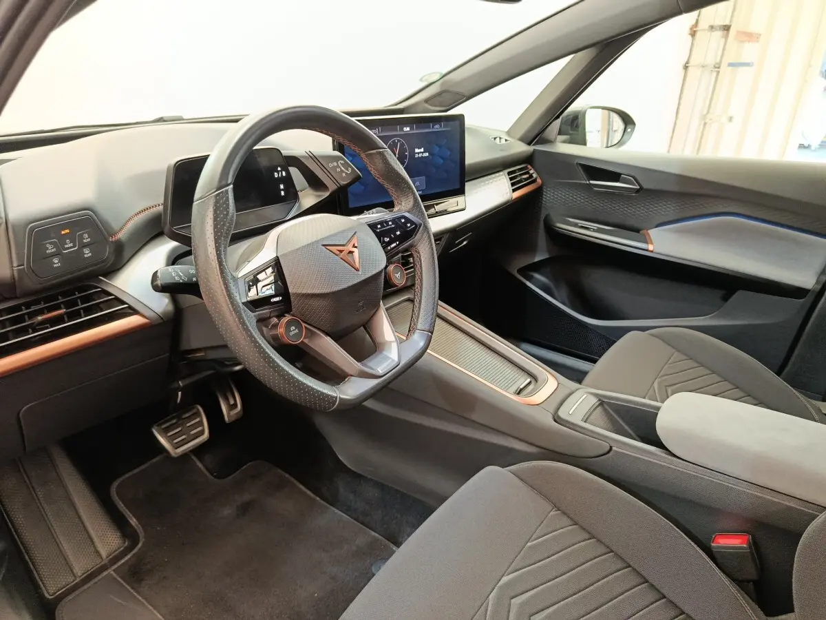 Vue intérieure côté conducteur du CUPRA BORN 230ch gris foncé, volant cuir multifonctions et écran tactile central.