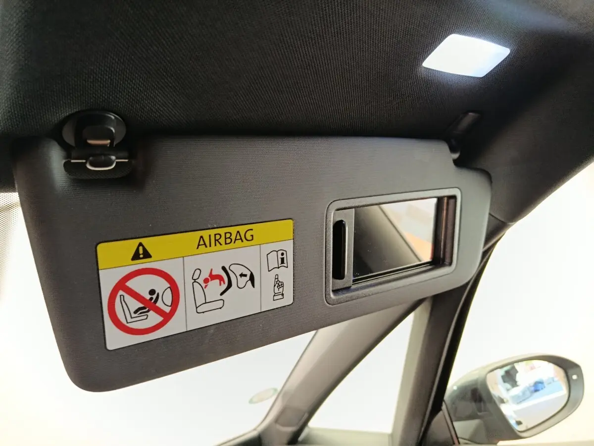 Détail du pare-soleil côté conducteur avec miroir intégré et étiquette airbag dans une CUPRA Born gris foncé 2023.
