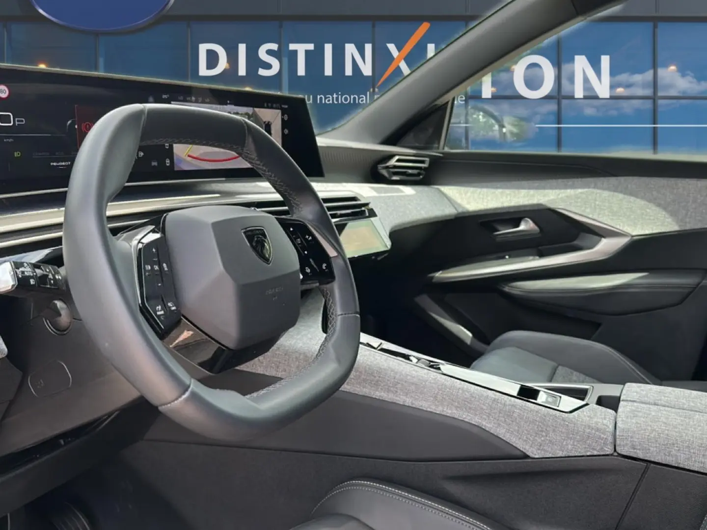Vue intérieure côté conducteur du Peugeot 3008 1.2 hybrid 145 allure 2025 avec volant cuir et tableau de bord numérique.