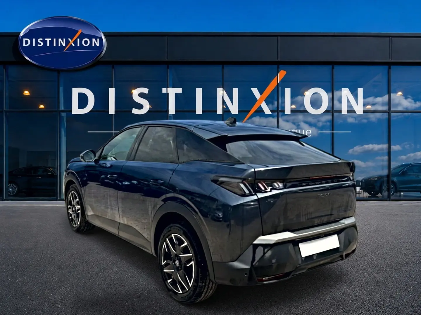 Vue 3/4 arrière d’un Peugeot 3008 gris titane 2025 avec jantes alu et feux arrière LED distinctifs.