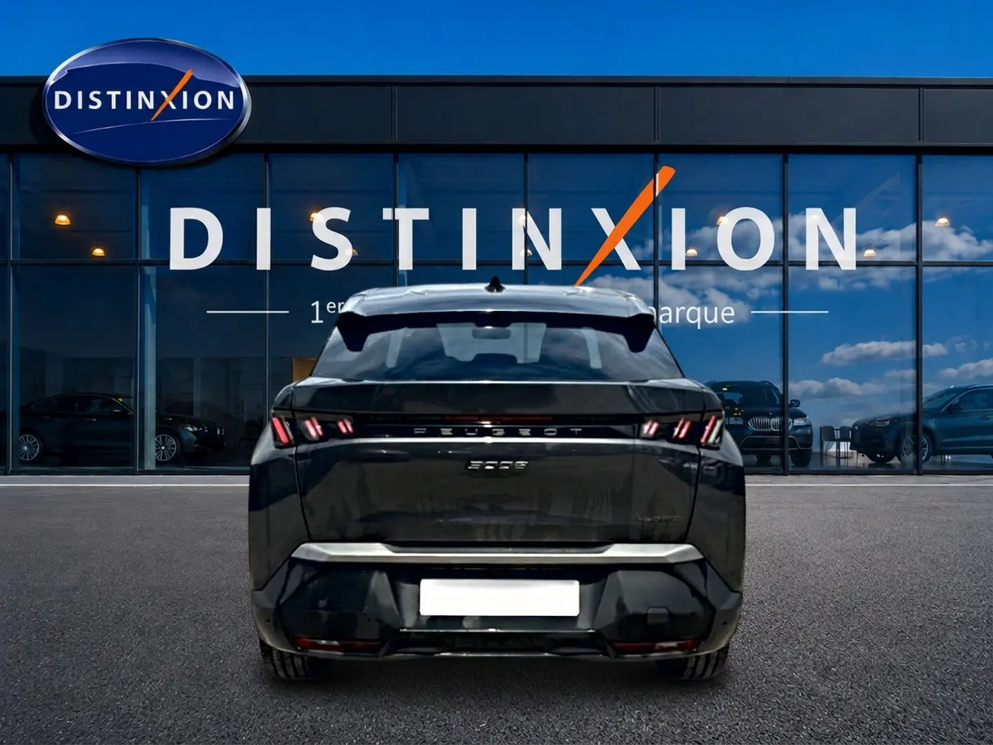 Vue arrière d'un Peugeot 3008 gris titane 2025 stationné devant une vitrine avec logo Distinxion.