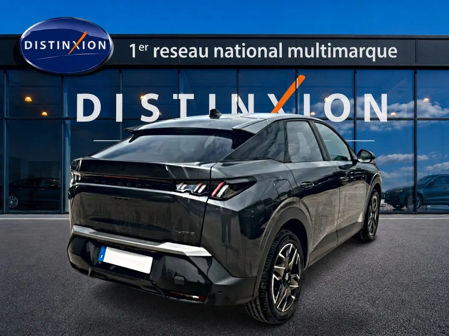Vue 3/4 arrière droite du Peugeot 3008 gris titane avec feux LED et jantes alliage devant un showroom Distinxion.