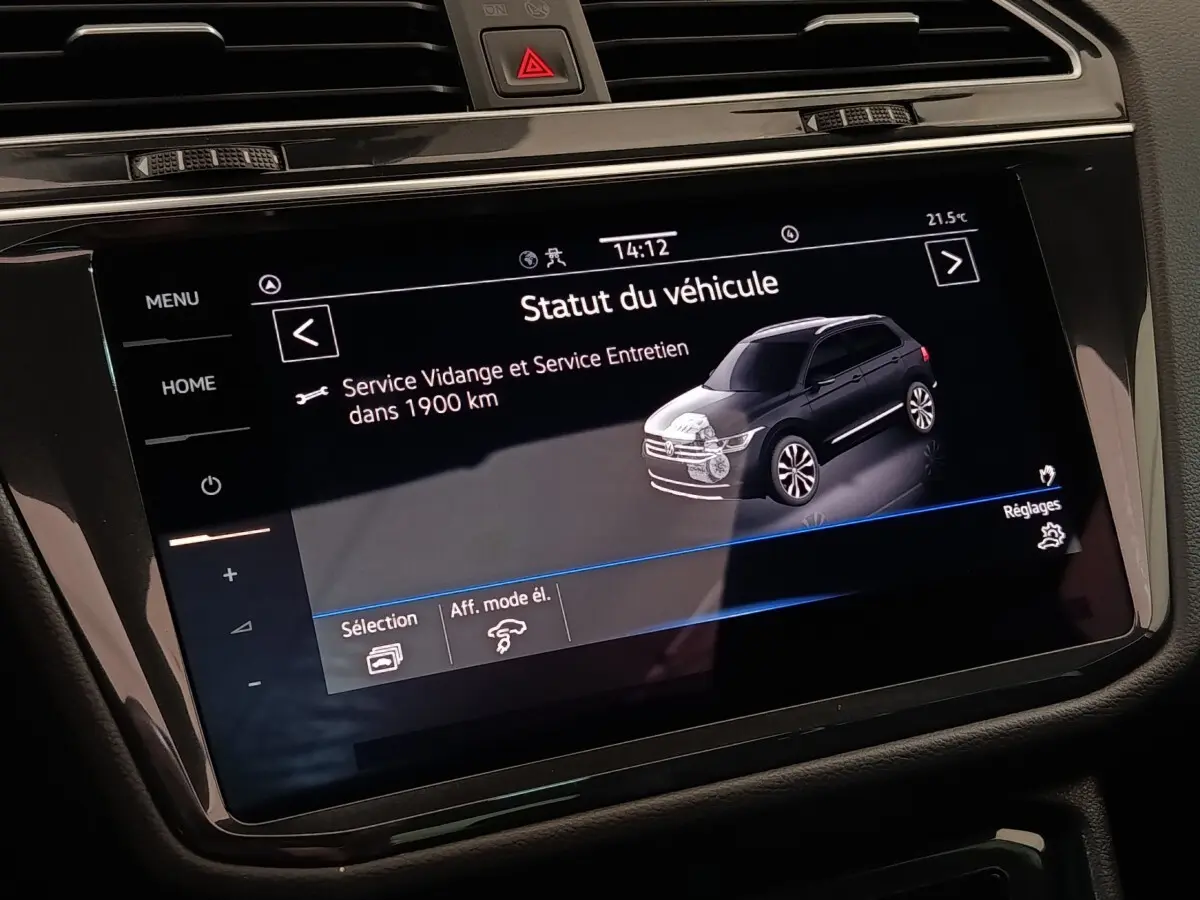Écran tactile central affichant le statut du véhicule Volkswagen Tiguan hybride, intérieur noir, vue rapprochée.