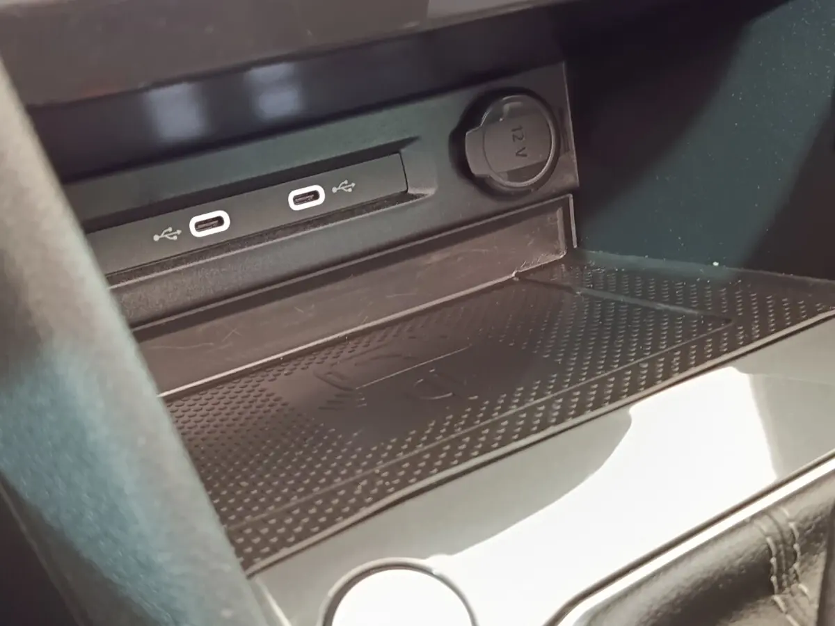 Gros plan sur la console centrale du Volkswagen Tiguan blanc, montrant les ports USB-C et prise 12V.