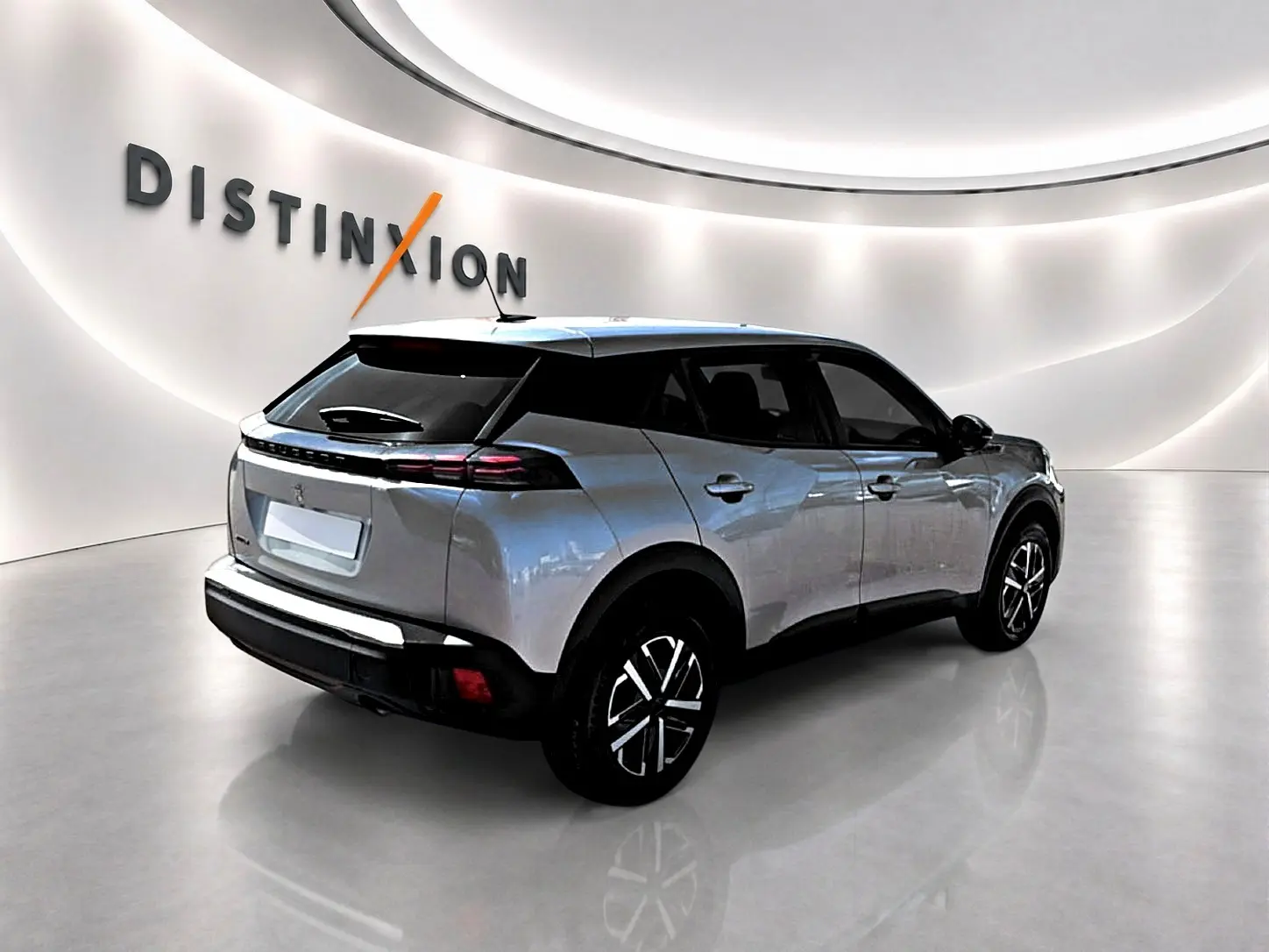 Peugeot 2008 gris en 3/4 arrière droit dans un showroom lumineux avec jantes noires et toit noir.