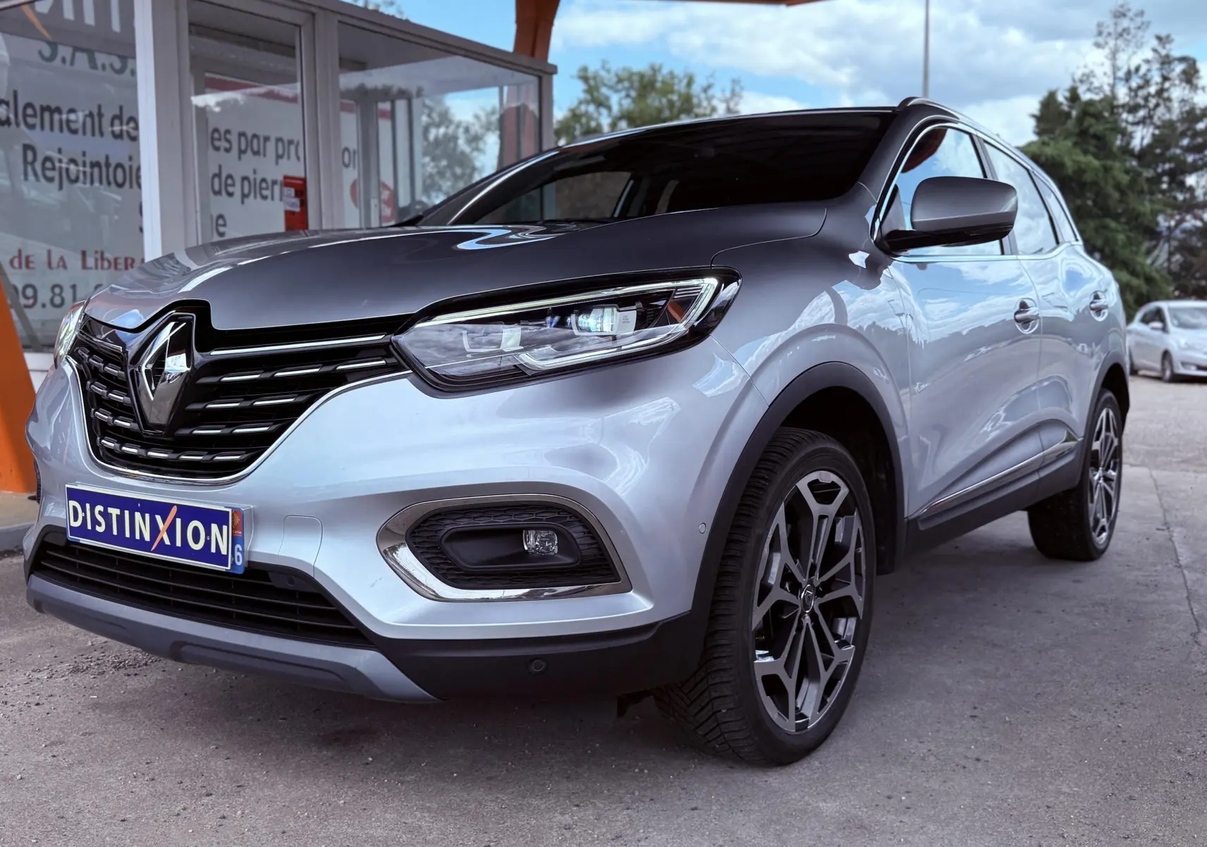 Renault Kadjar gris en 3/4 avant droit, avec calandre noire et jantes alliage distinctives.
