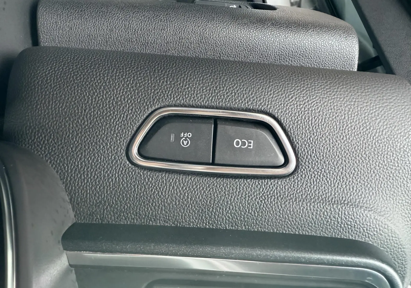 Gros plan sur les boutons ECO et arrêt auto du moteur dans l'habitacle du Renault Kadjar gris 2020.